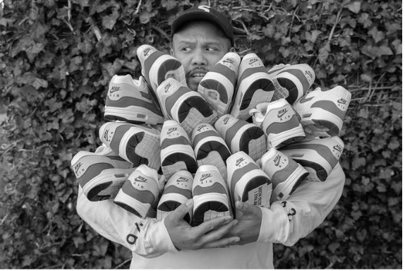 Oliver holding sneakers in front of a green wall