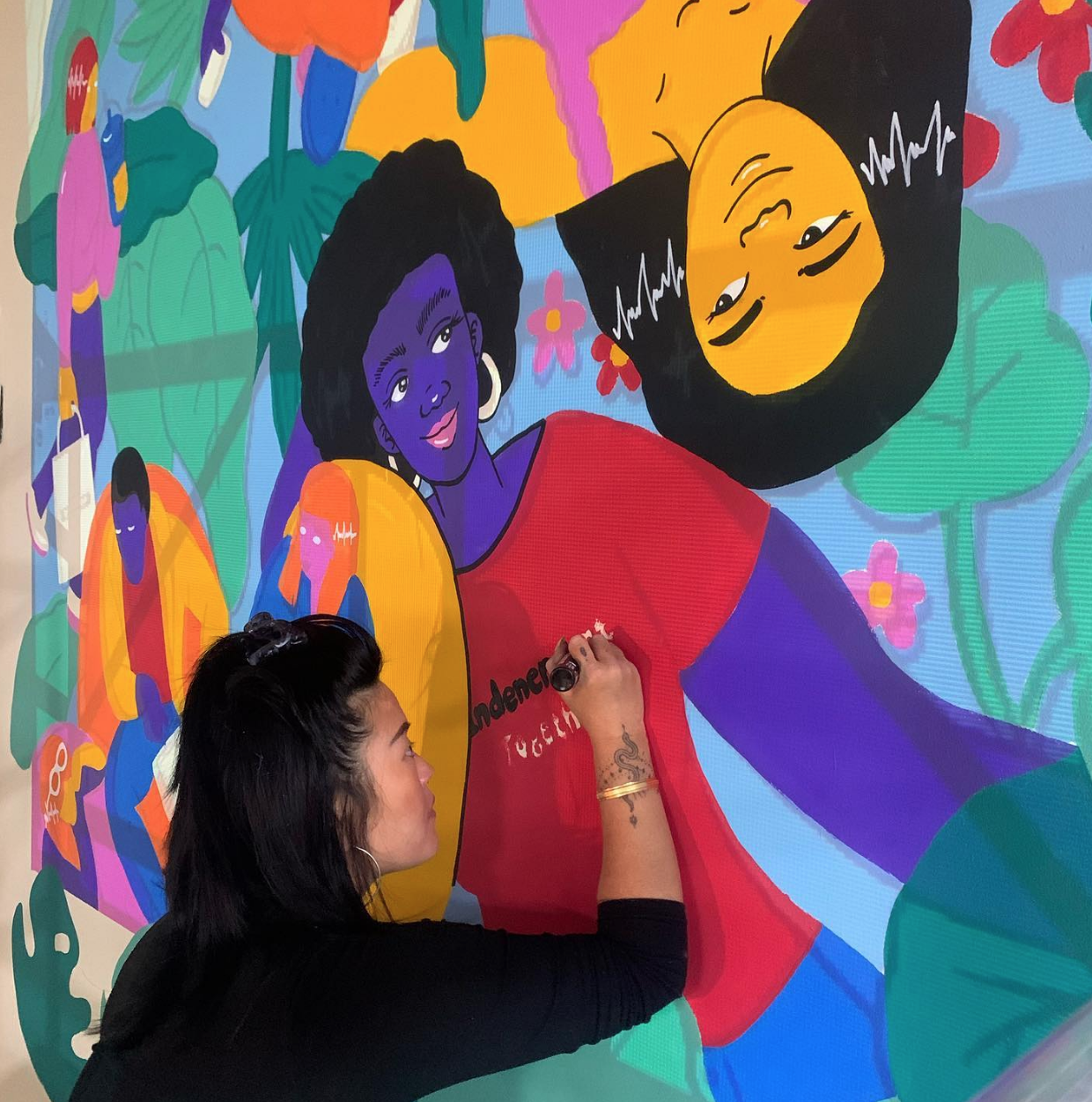 Artist painting a mural inside WRKSHOP